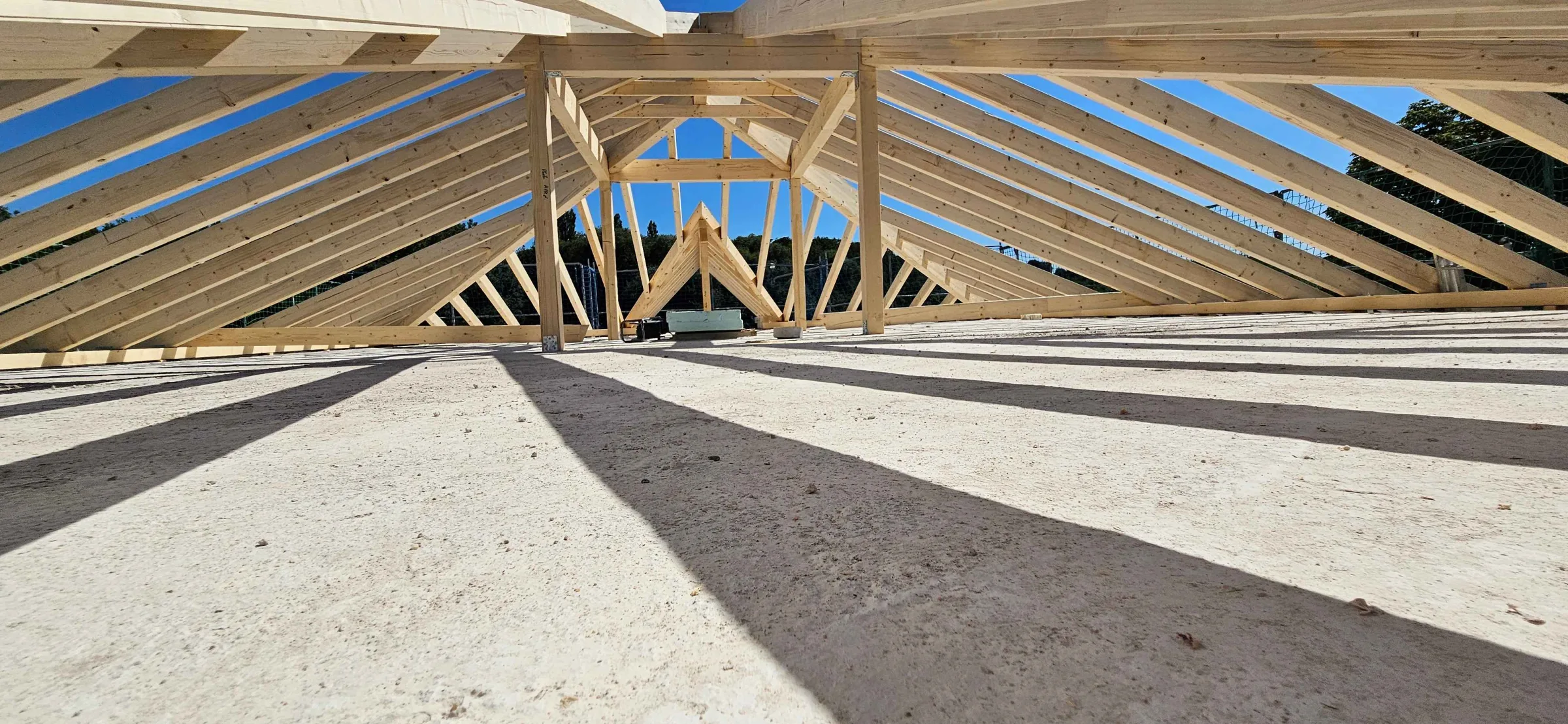 Neuer Dachstuhl aus Holz von innen, im Sonnenlicht
